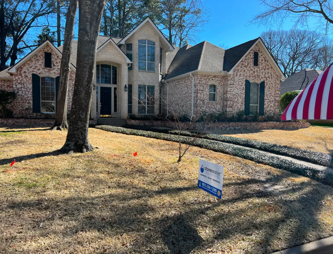 Front of a home with a Stonewater Roofing sign in the yard