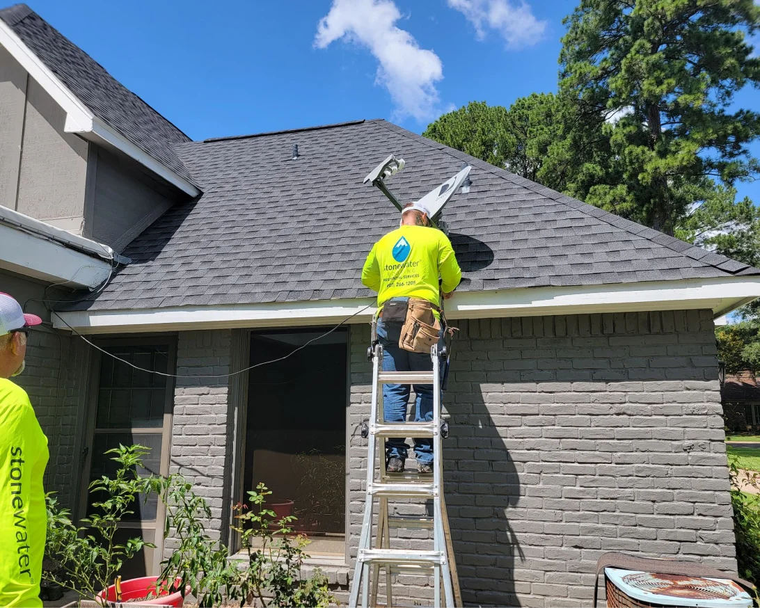 Man standing on ladder and working on roof